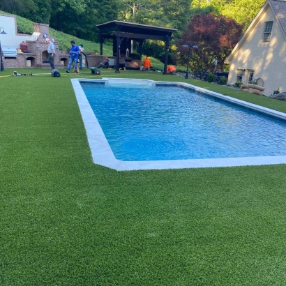 Artificial grass around backyard swimming pool by American Syn-Turf, Toccoa Georgia - low-maintenance, lush green synthetic turf for poolside landscaping